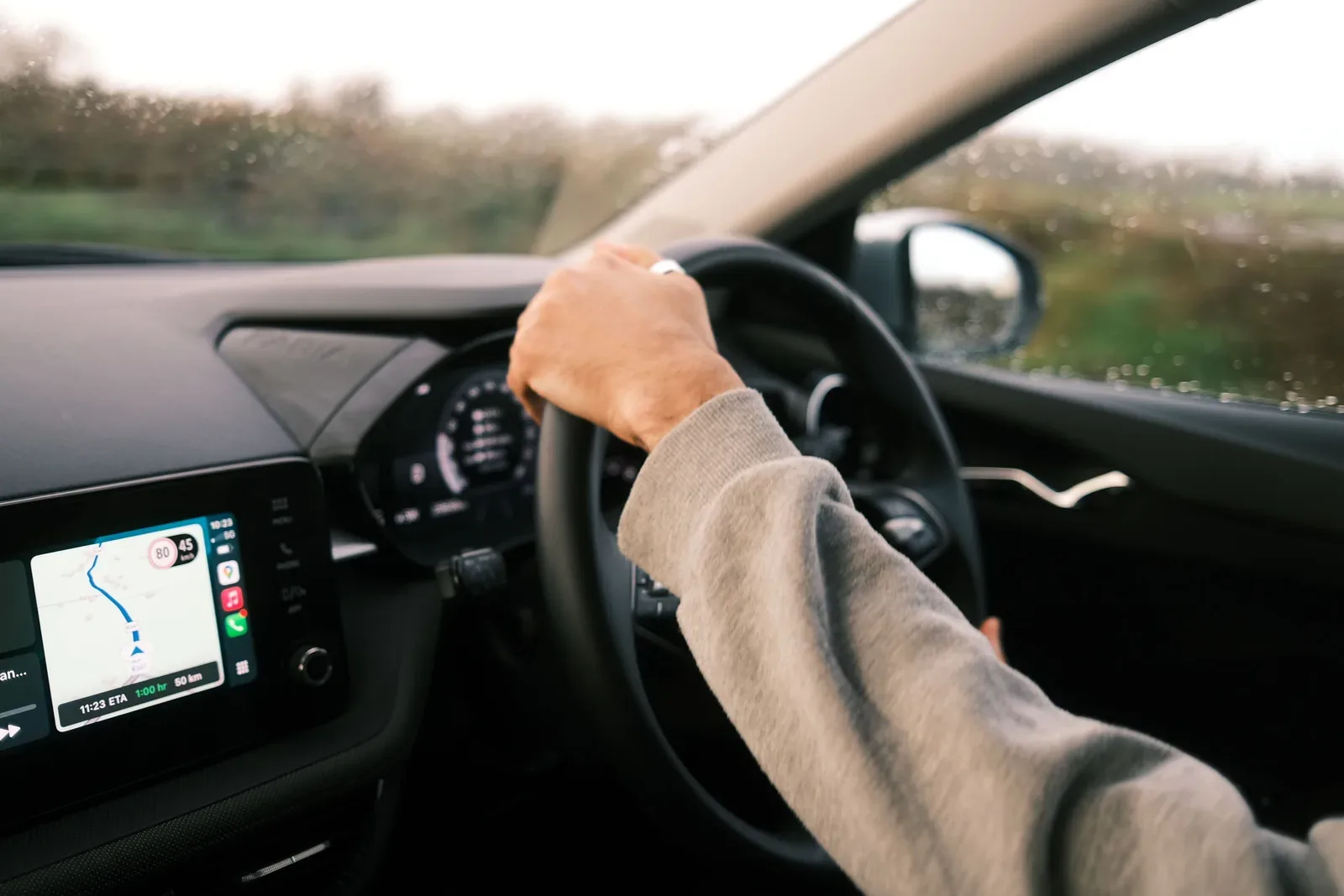 Conductor utilizando la navegación del vehículo en carretera mojada