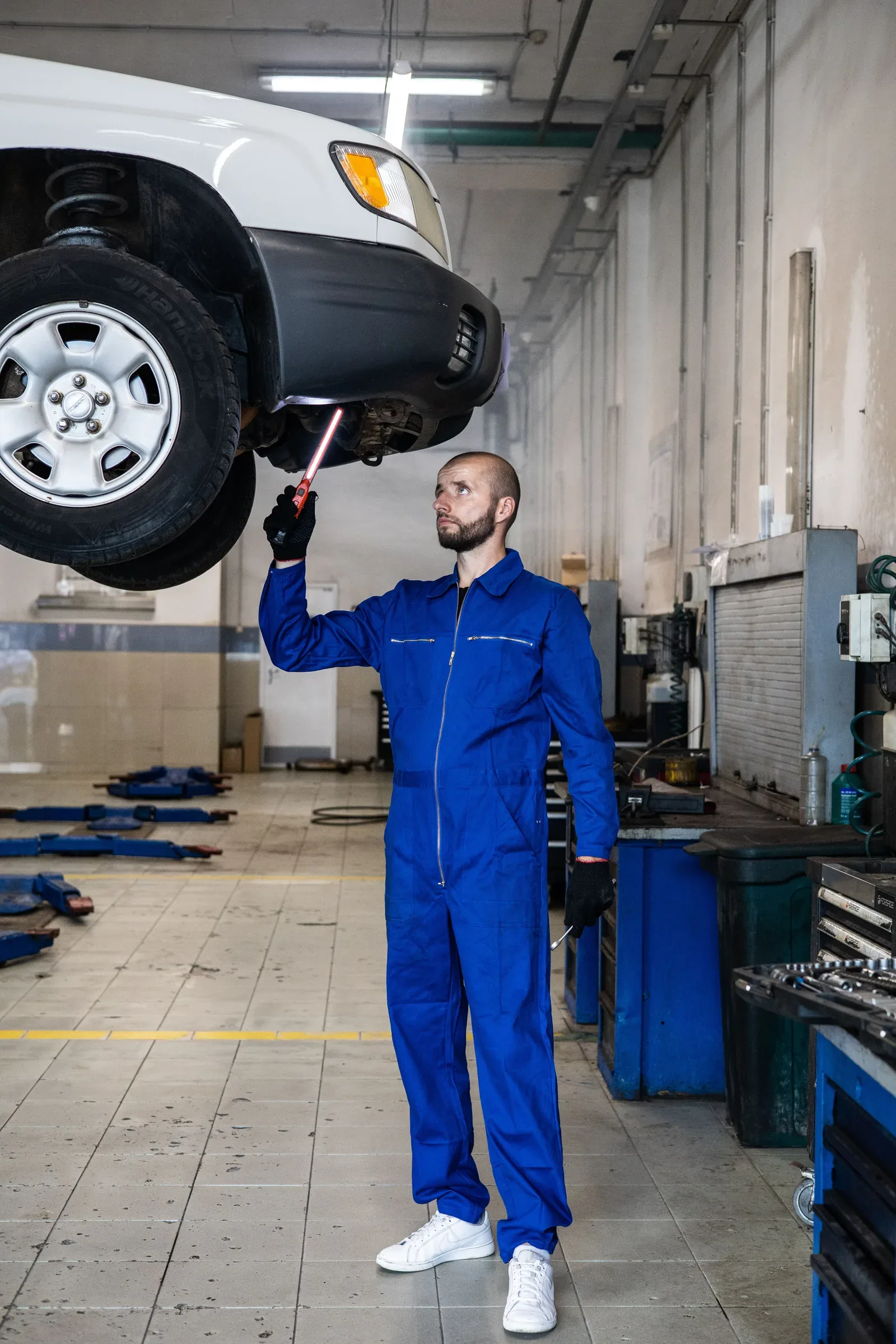 Mecánico trabajando bajo un vehículo en un taller